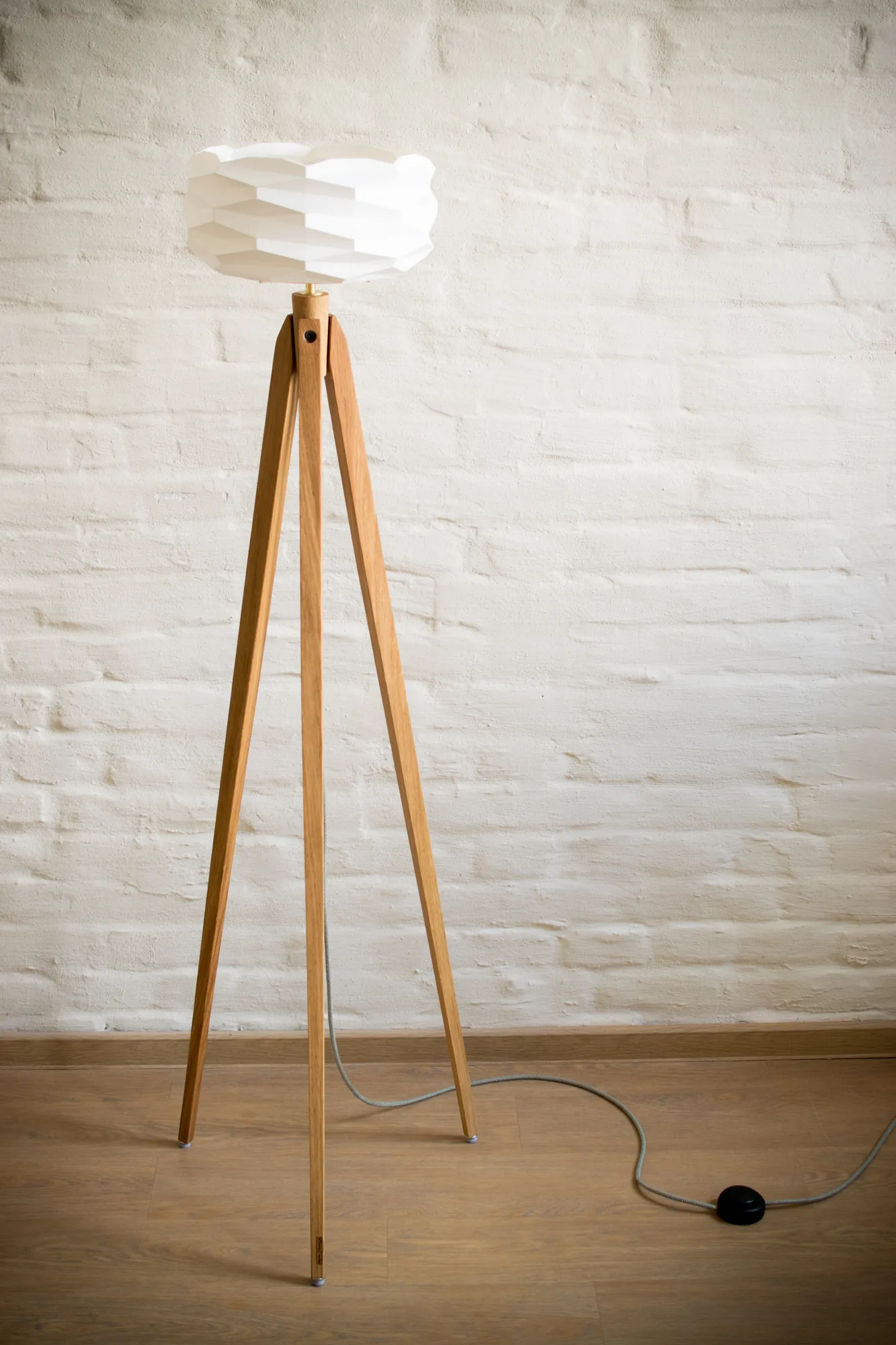 Stehlampe mit Tripod aus Eiche, Wabenschirm aus weißem Material, weiße Backsteinwand