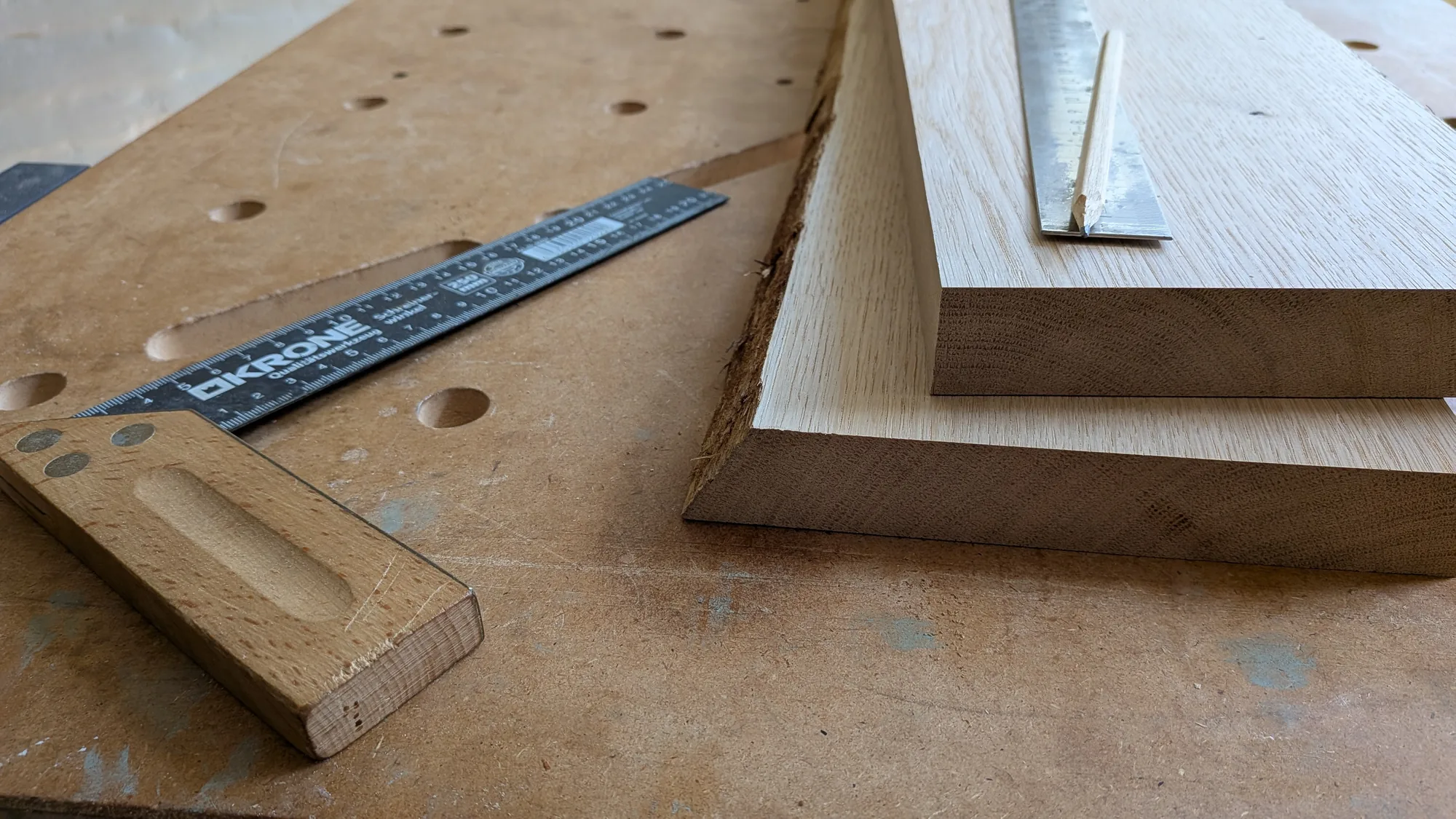 Werkbank im Atelier mit zugeschnittenen Eichenbrettern, KRONE Anschlagwinkel und Bleistift